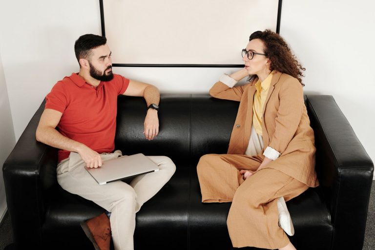 Two professionals seated in conversation, one listening closely